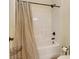 Full bathtub and shower combo with a neutral shower curtain and fixtures at 13519 Crystal Springs Dr # 148, Huntersville, NC 28078