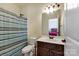 Bright bathroom features a shower with striped curtain and modern vanity with sleek fixtures at 13519 Crystal Springs Dr # 148, Huntersville, NC 28078