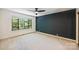 Neutral bedroom features dark accent wall, plush carpet, and a large window with wooded view at 1419 Jules Ct, Charlotte, NC 28226