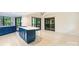 Open kitchen featuring an island with gas cooktop, bright floors, blue cabinets, and sliding doors to the deck at 1419 Jules Ct, Charlotte, NC 28226