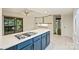 Modern kitchen with white cabinets, blue island with gas cooktop, and sliding glass doors to a screened deck at 1419 Jules Ct, Charlotte, NC 28226