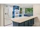 A modern kitchen features updated appliances, light countertops, blue cabinets and a gas cooktop on the island at 1419 Jules Ct, Charlotte, NC 28226