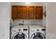 Laundry room featuring a washer and dryer, white walls and cabinets, and white louvered doors at 1419 Jules Ct, Charlotte, NC 28226