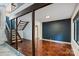 Well lit living room with hardwood floors, staircase, dark accent wall and wood beams at 1419 Jules Ct, Charlotte, NC 28226