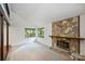Bright living room features a stone fireplace with a raised hearth and views of the surrounding trees at 1419 Jules Ct, Charlotte, NC 28226