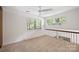 Carpeted loft space with natural light, a ceiling fan, and staircase overlooking the room with a metal railing at 1419 Jules Ct, Charlotte, NC 28226