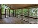 Spacious screened porch with wood flooring, a ceiling fan, and a lush wooded view from the windowed walls at 1419 Jules Ct, Charlotte, NC 28226