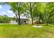 Well-maintained yard with mature trees, fire pit, and backyard view of the house at 1426 Larkfield Ln, Charlotte, NC 28210