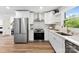 Stylish kitchen featuring stainless steel appliances, white countertops, and custom cabinetry at 1426 Larkfield Ln, Charlotte, NC 28210
