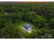 Aerial view of a home with a dark roof, surrounded by mature trees in a peaceful, wooded setting at 1622 Burtonwood Cir, Charlotte, NC 28212