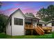Stunning back exterior with a wooden deck, white brick, dark trim and well-manicured lawn at 1622 Burtonwood Cir, Charlotte, NC 28212