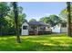 The backyard features a well-maintained lawn, a modern home, and an inviting deck at 1622 Burtonwood Cir, Charlotte, NC 28212