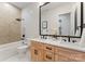Bathroom featuring double vanity with light wood cabinets and modern fixtures at 1622 Burtonwood Cir, Charlotte, NC 28212