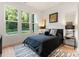 Well-lit bedroom featuring hardwood floors and three large windows at 1622 Burtonwood Cir, Charlotte, NC 28212
