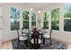Bright dining area with a modern light fixture, a round table, and large windows showcasing the outside trees at 1622 Burtonwood Cir, Charlotte, NC 28212