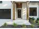 Welcoming entryway featuring wood columns, a modern front door with glass panels, and fresh landscaping at 1622 Burtonwood Cir, Charlotte, NC 28212