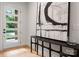 Bright entryway with a modern door, stylish console table, contemporary art, and beautiful wood floors at 1622 Burtonwood Cir, Charlotte, NC 28212