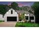 Beautifully landscaped front exterior showcasing a white brick facade, dark trim, and a modern black garage at 1622 Burtonwood Cir, Charlotte, NC 28212