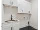 Laundry room featuring modern cabinets, black and white tile floor, and a utility sink at 1622 Burtonwood Cir, Charlotte, NC 28212