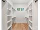 Bright walk-in closet features custom white shelving and hardwood floors at 1622 Burtonwood Cir, Charlotte, NC 28212