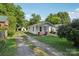 Home with a long driveway and detached garage surrounded by mature trees and lush greenery at 1626 W Park Ave, Albemarle, NC 28001