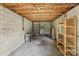 Interior of garage showing cinder block walls, exposed wood ceiling, shelving, and concrete floor at 1626 W Park Ave, Albemarle, NC 28001