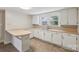 Well-lit kitchen featuring white cabinets, light countertops, and a double sink beneath a window at 1626 W Park Ave, Albemarle, NC 28001