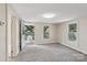 Bright living room with neutral walls, gray carpet, and natural light from windows and an open door at 1626 W Park Ave, Albemarle, NC 28001