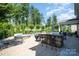 Backyard featuring an outdoor kitchen, jacuzzi, and grill with chairs around it at 183 Canoe Pole Ln, Mooresville, NC 28117