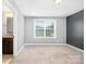 Bedroom with gray walls, light carpet, and a large window offering natural light at 183 Canoe Pole Ln, Mooresville, NC 28117