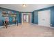 Bonus room with blue walls, carpet flooring, desk and shelving at 183 Canoe Pole Ln, Mooresville, NC 28117