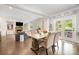 Open dining area with hardwood floors, a wooden table, and chairs, with views into the living room and backyard at 183 Canoe Pole Ln, Mooresville, NC 28117