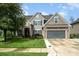 Inviting home showcasing stone accents, dark shutters, and a well-maintained lawn in a sunny setting at 183 Canoe Pole Ln, Mooresville, NC 28117