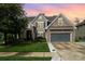Beautiful home with warm tones, manicured lawn, and stone accents during a colorful sunset at 183 Canoe Pole Ln, Mooresville, NC 28117