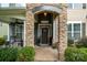 Inviting front porch with stone columns and a decorative front door with seasonal decorations at 183 Canoe Pole Ln, Mooresville, NC 28117