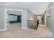 Upstairs hallway with carpet flooring, wood railing, and views into other rooms at 183 Canoe Pole Ln, Mooresville, NC 28117