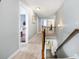 Upstairs hallway with carpet flooring, wood railing, and views into other rooms at 183 Canoe Pole Ln, Mooresville, NC 28117