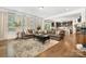 Bright living room featuring hardwood floors, large windows with white curtains, and comfortable seating arrangements at 183 Canoe Pole Ln, Mooresville, NC 28117