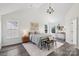A cozy bedroom shows natural light, a chandelier, stylish decor and luxury flooring at 1986 Trace Creek Dr, Waxhaw, NC 28173