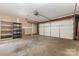View of the spacious two-car garage with a white door and black metal shelves at 2001 Enderbury Dr, Indian Trail, NC 28079