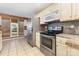 A well-lit kitchen featuring stainless steel appliances, cream cabinets, and a window with wood blinds at 2001 Enderbury Dr, Indian Trail, NC 28079