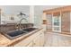 Close-up of the kitchen sink, with a view into the open living space and window with wood blinds at 2001 Enderbury Dr, Indian Trail, NC 28079