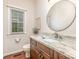 Elegant powder room boasts granite counters, a stylish round mirror, and attractive dark wood cabinetry at 205 Rosedale Ln, Matthews, NC 28105