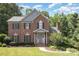 Charming brick home with a manicured lawn, mature trees, and gray shutters at 205 Rosedale Ln, Matthews, NC 28105
