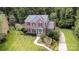 Stunning exterior of a brick home featuring manicured landscaping, a lush lawn, and a charming blue front door at 205 Rosedale Ln, Matthews, NC 28105