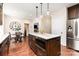 Open kitchen features a large center island, stainless steel appliances, granite countertops, and wood floors at 205 Rosedale Ln, Matthews, NC 28105