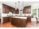 Beautiful kitchen with dark wood cabinets, an island, marble countertops, and hardwood floors at 205 Rosedale Ln, Matthews, NC 28105