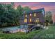 A captivating rear exterior view showcasing a brick home with a deck and an attached two-car garage at 205 Rosedale Ln, Matthews, NC 28105