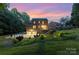 A captivating rear view of a brick home featuring a deck, a two-car garage, and lush landscaping at 205 Rosedale Ln, Matthews, NC 28105