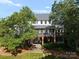 View of the rear of this home with a large porch, screened in area, and expansive backyard at 2324 Kingsmill Ter, Charlotte, NC 28270